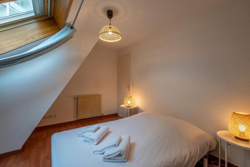 a bedroom with a white bed with three towels on it at Pleasant apartment three minutes from the center of Annecy in Annecy