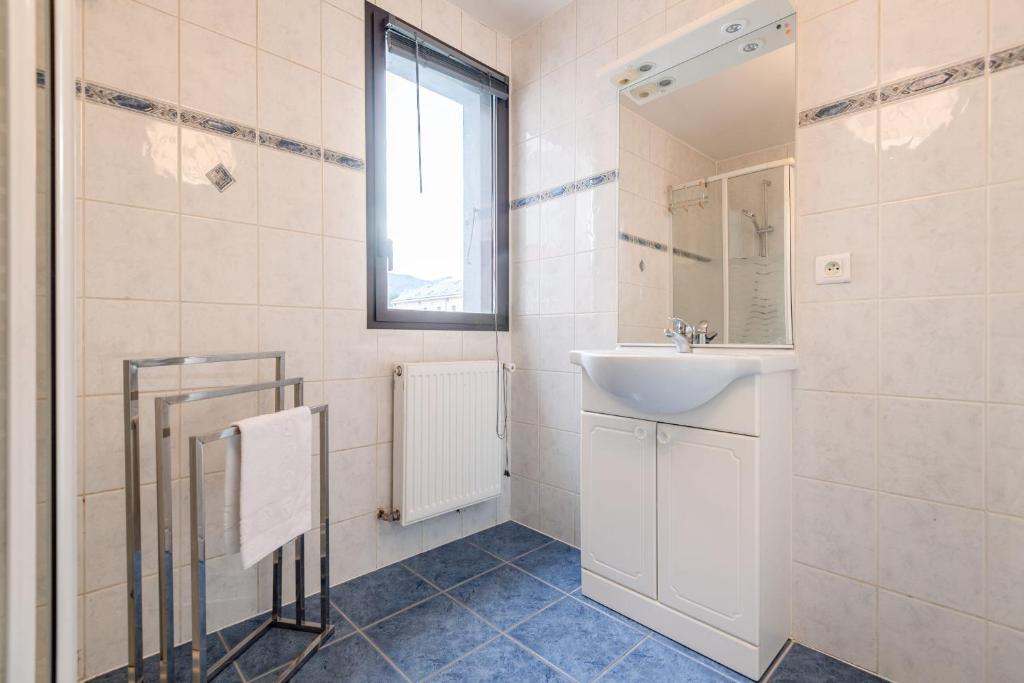 a white bathroom with a sink and a mirror at Pleasant apartment three minutes from the center of Annecy in Annecy