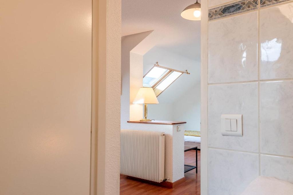 a bathroom with a shower and a lamp on a table at Pleasant apartment three minutes from the center of Annecy in Annecy