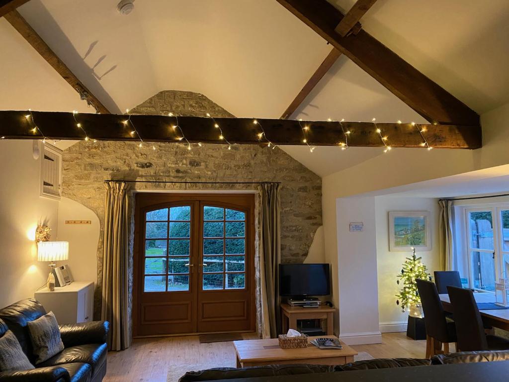 Norburton Hall Cottages في بريدبورت: غرفة معيشة مع أريكة وباب مع أضواء