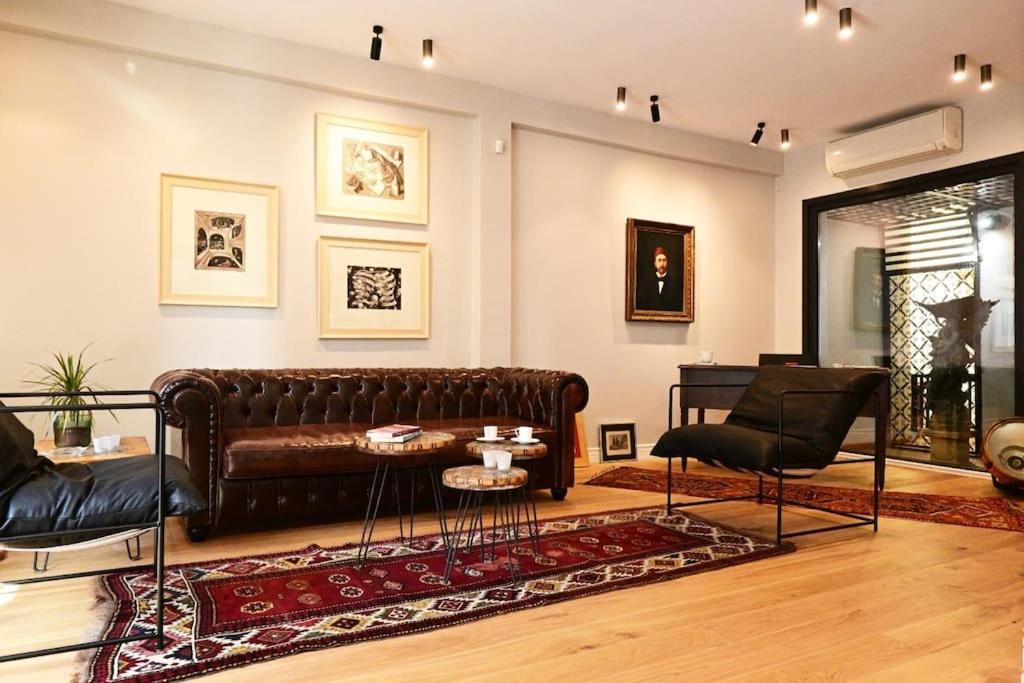 a living room with a leather couch and chairs at Architect's Art House right on Taksim Square in Istanbul