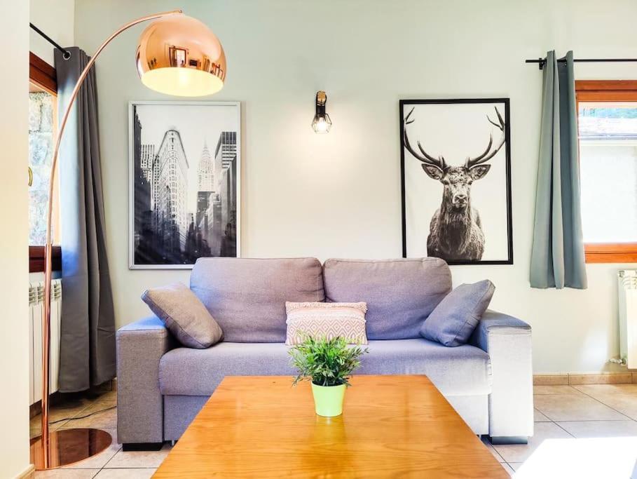 uma sala de estar com um sofá azul e uma mesa em Disfruta De La Naturaleza - Vistas al Rio - Luz Natural - 6pax em Canillo