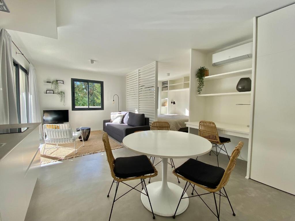 a living room with a table and chairs and a couch at STUDIO in res. LES CYCLISTES in Malaucène