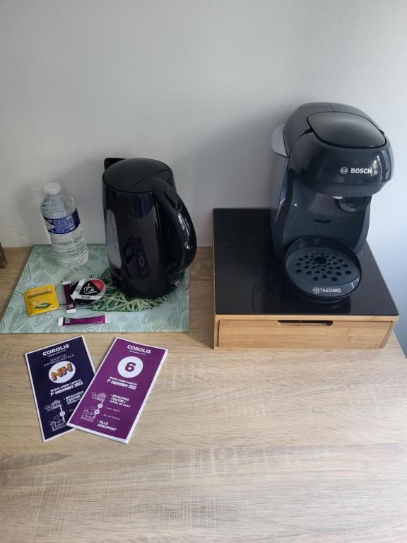 une cafetière assise sur une table à côté d'une boîte dans l'établissement Iago Lodge, à Beauvais