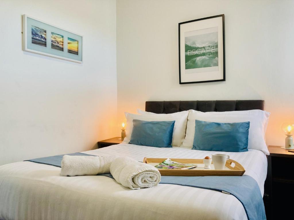 a bedroom with two beds with a tray on the bed at Westcliffe Apartments in Southport