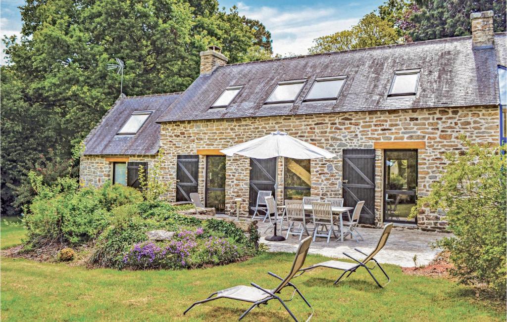 a stone house with a table and chairs in the yard at Holiday Home Pont Aven Coteau De Keramperchec in Pont-Aven