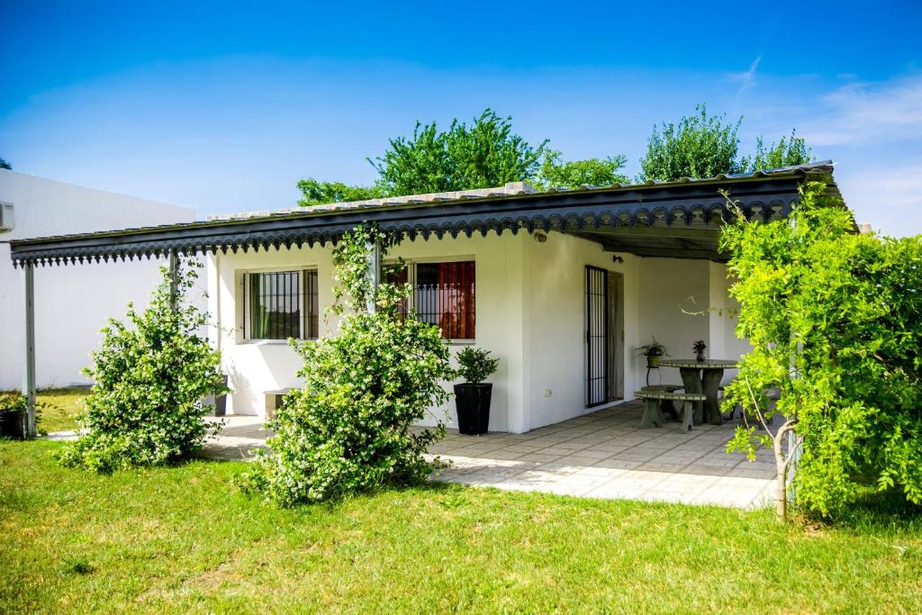 una pequeña casa blanca con una mesa en el patio en Posada Casablanca en Olavarría