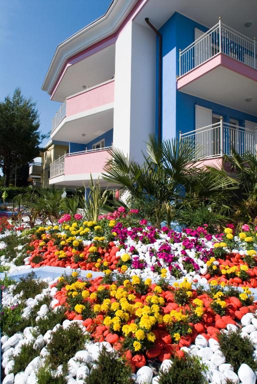 a bed of flowers in front of a building at Villa Boer in Bibione