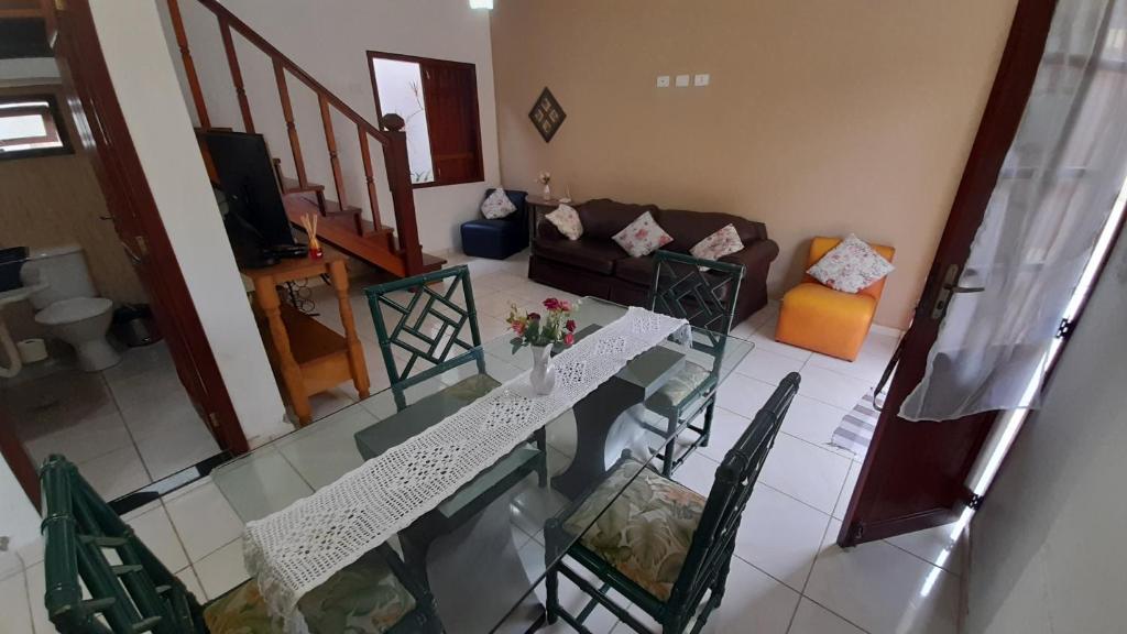 uma sala de estar com uma mesa de vidro e cadeiras em Casa Show em Paraty