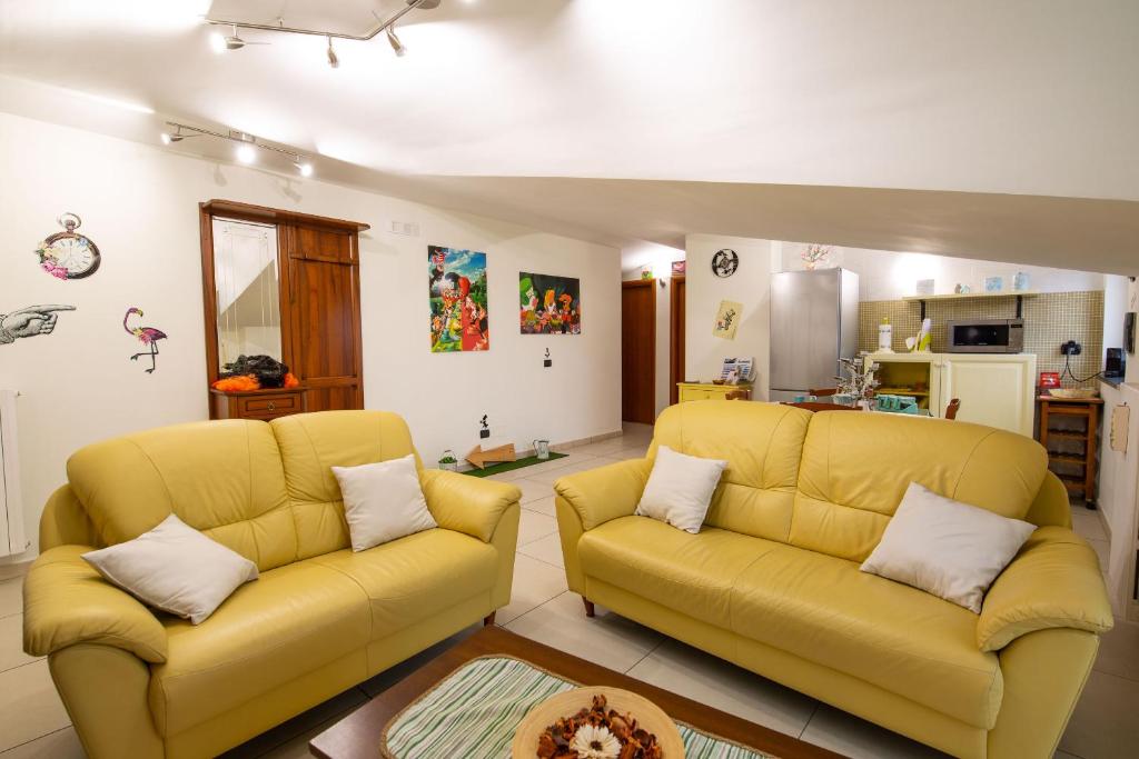 un soggiorno con 2 divani gialli e una cucina di B&B delle Meraviglie Salerno-Baronissi-Pellezzano a Pellezzano