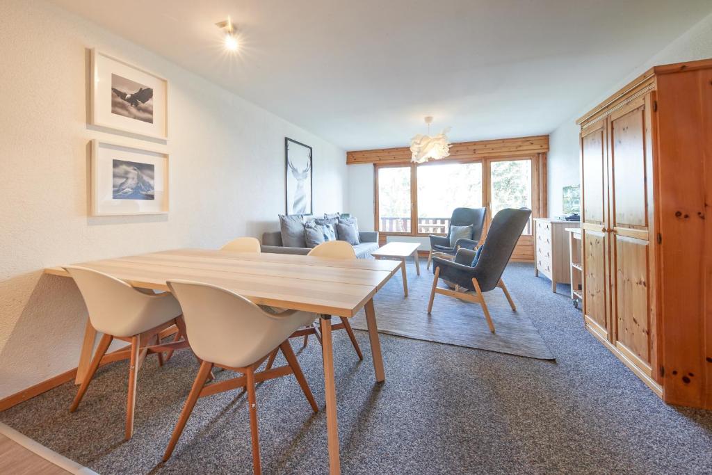 a dining room with a wooden table and chairs at Cosy studio for 5 near ski lift, HAMEAU D2 in Les Collons