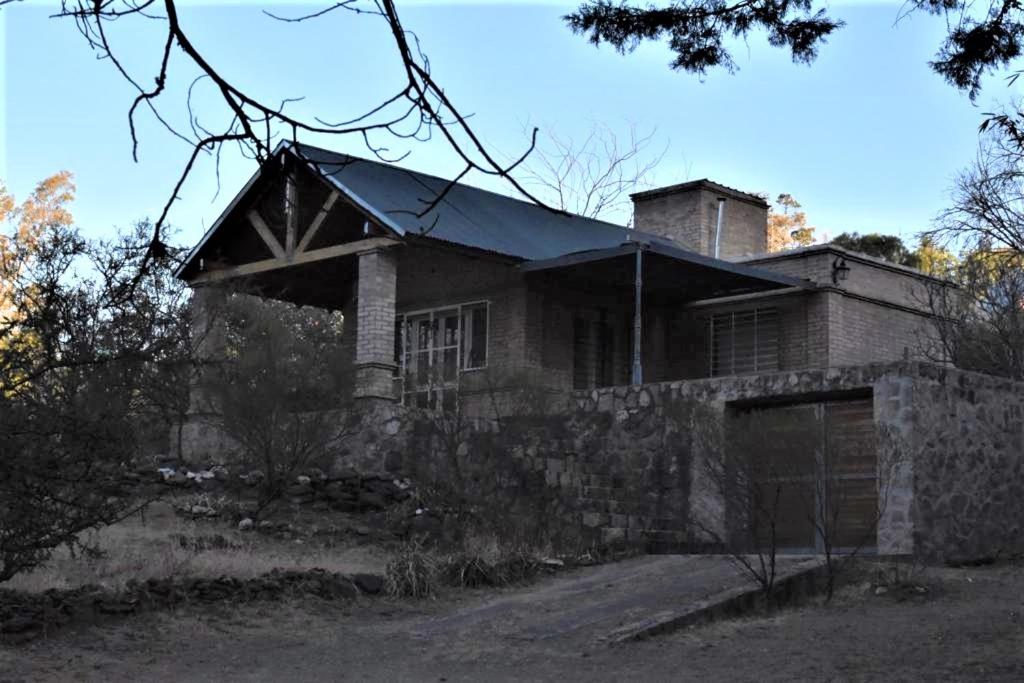 una vieja casa de ladrillo con una chimenea encima en Casa Iguana en Cuesta Blanca en Villa Icho Cruz