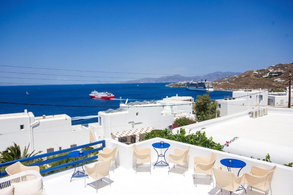 Un balcón con sillas y vistas al océano. en Hotel Spanelis, en Mykonos ciudad