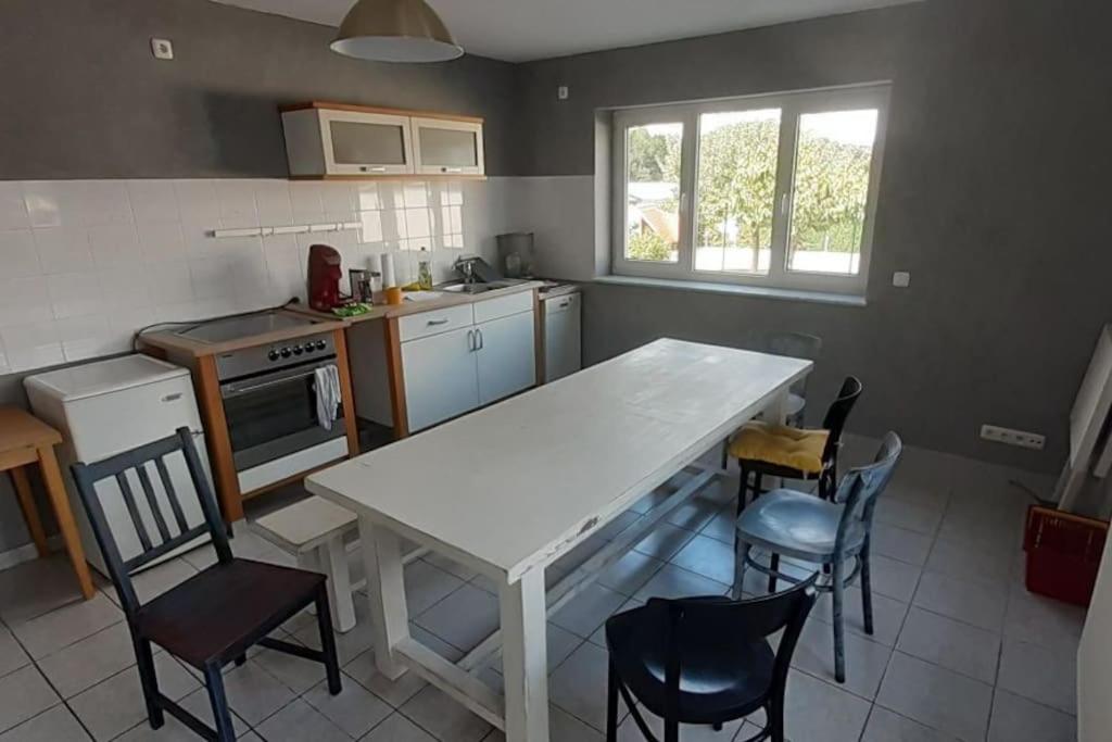 una cocina con mesa blanca y sillas. en Kleine Wohnung in Langgöns en Langgöns