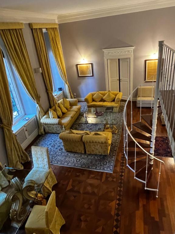 a living room with couches and a stair case at Holiday House Belle Arti - NEL CUORE DI ROMA in Rome