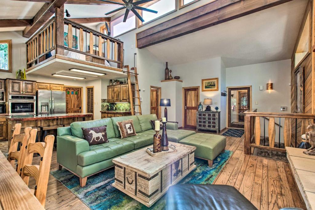 ein Wohnzimmer mit einem grünen Sofa und einem Tisch in der Unterkunft Cozy Angel Fire Escape with Golf Course Views! in Angel Fire