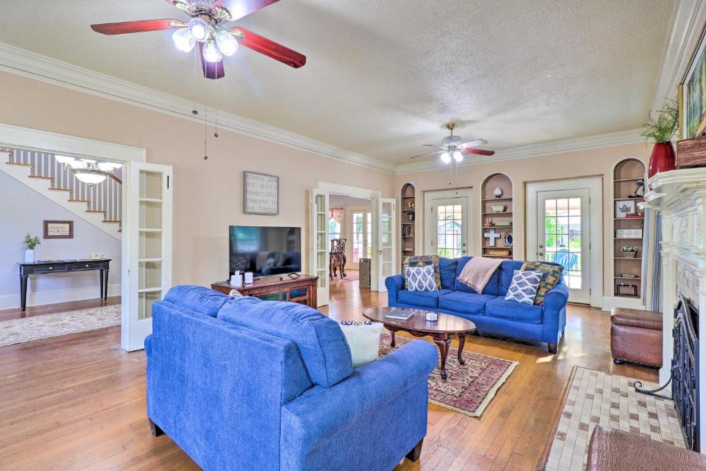 a living room with two blue couches and a fireplace at Historic 1927 Corsicana Getaway with Game Room! in Corsicana