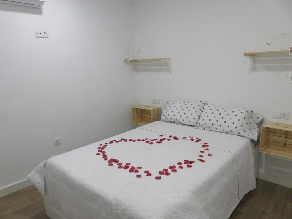 Una cama con un corazón hecho de rosas en Belice, excepcional apartamento con Jacuzzi, en Punta Umbría