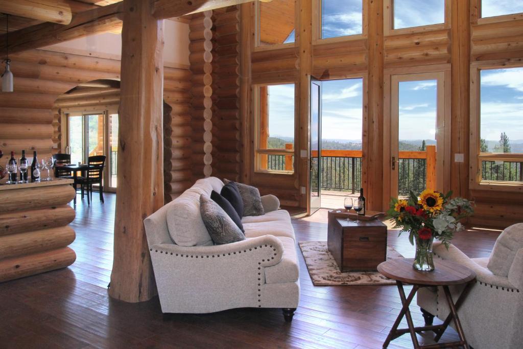 a living room with couches in a log cabin at Courtwood Inn in Murphys