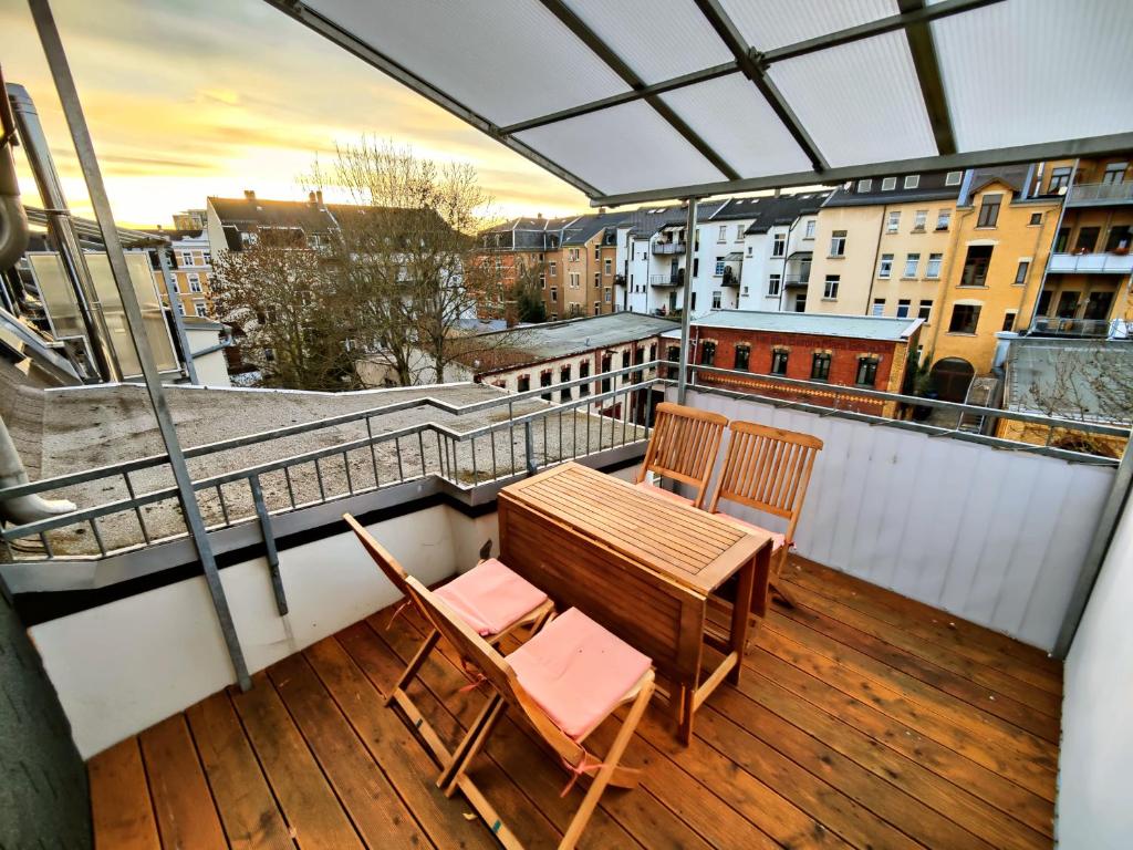uma varanda com uma mesa de madeira e 2 cadeiras em YourFavoriteBed 100m2 Designwohnung mit Vollausstattung em Plauen