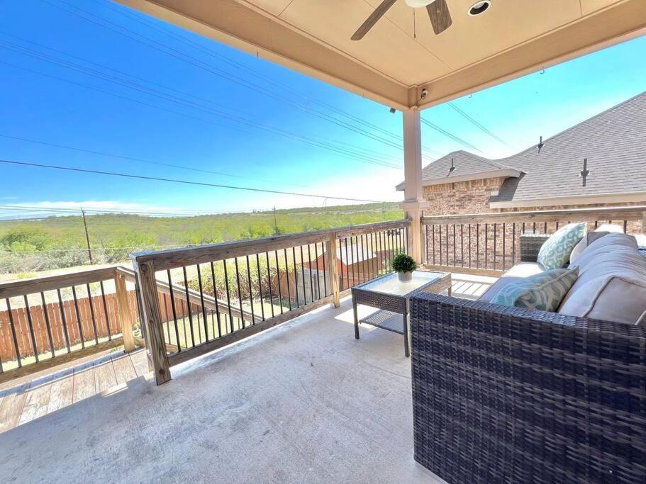 a patio with a couch and a table on a balcony at Furnished, Modern & Spacious Home - AFB Guests Special - Media Room, Self Checkin, Garage in San Antonio