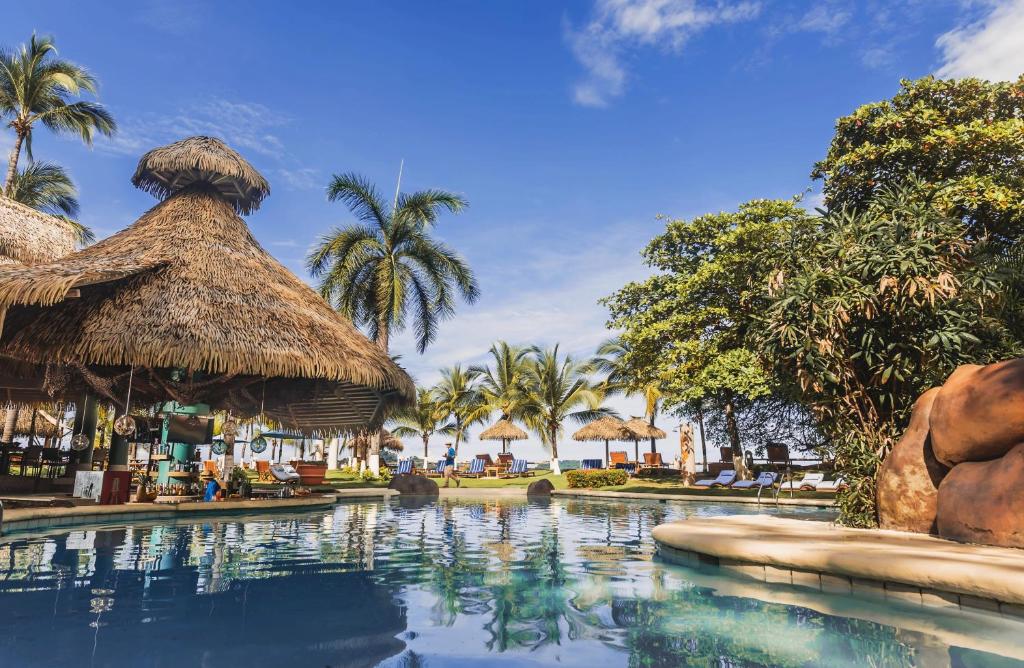 a swimming pool at a resort with palm trees at Bahia del Sol Beach front Boutique Hotel in Potrero