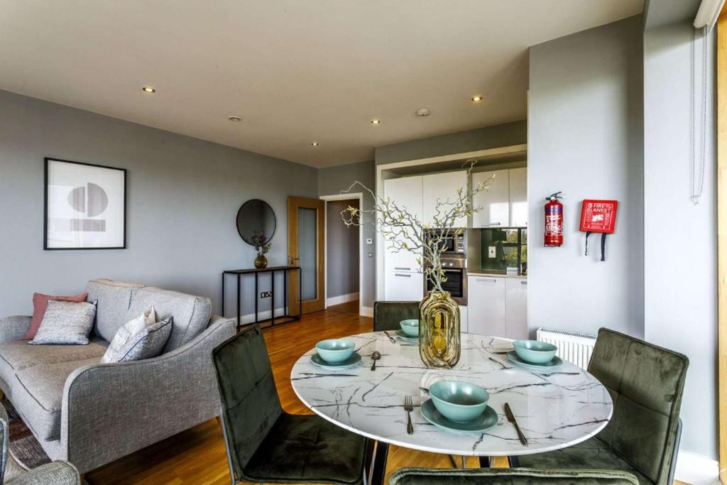 uma sala de estar com uma mesa e um sofá em Private Room Available in Spacious High Rise Apartment with Park & City View em Dublin