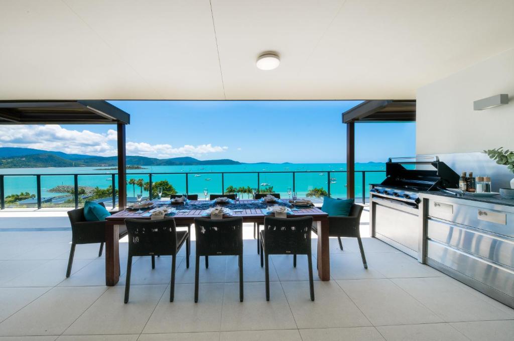 uma sala de jantar com uma mesa e vista para o oceano em 180 Degrees em Cannonvale