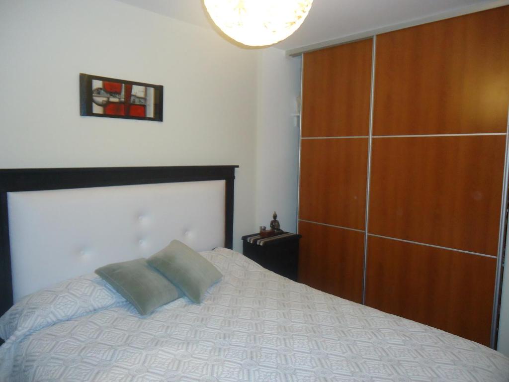 1 dormitorio con 1 cama y un gran armario de madera en Sweet apart Nueva Córdoba en Córdoba