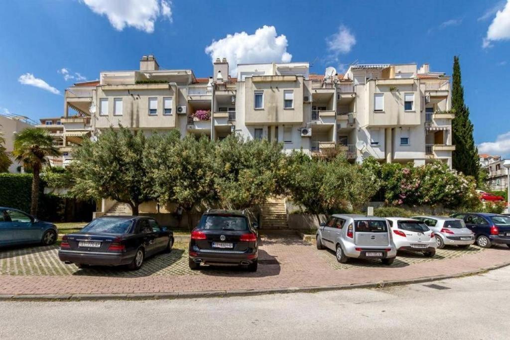 un parcheggio con auto parcheggiate di fronte a un edificio di Apartments with WiFi Split - 13120 a Spalato (Split)