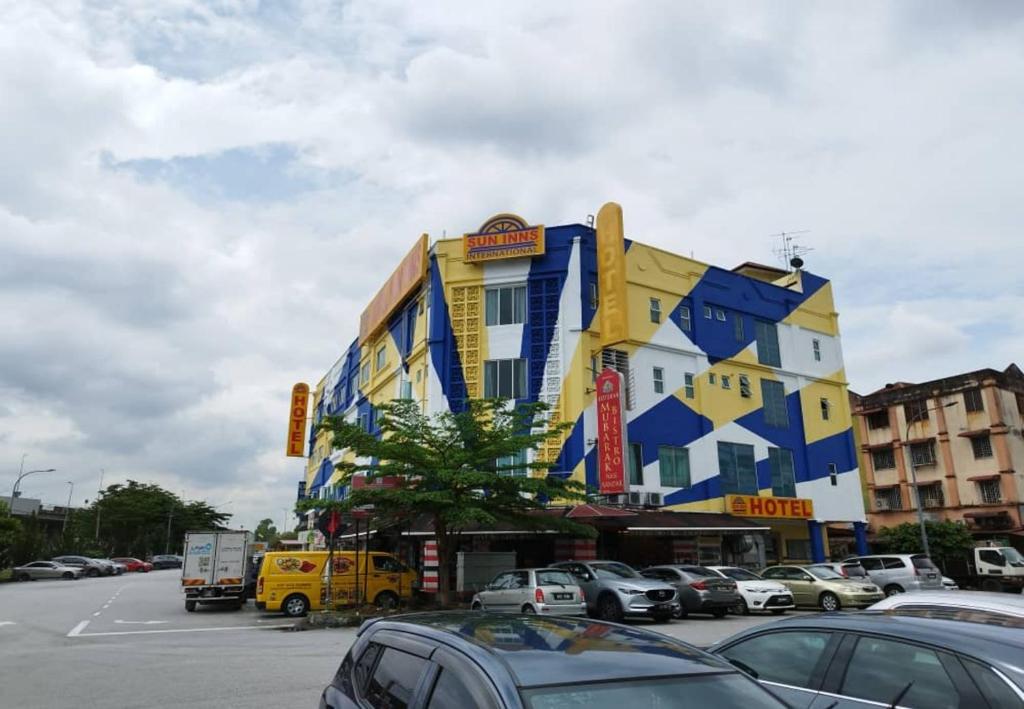 un edificio amarillo y azul con coches estacionados en un estacionamiento en Sun Inns Hotel Cheras - Balakong, en Cheras