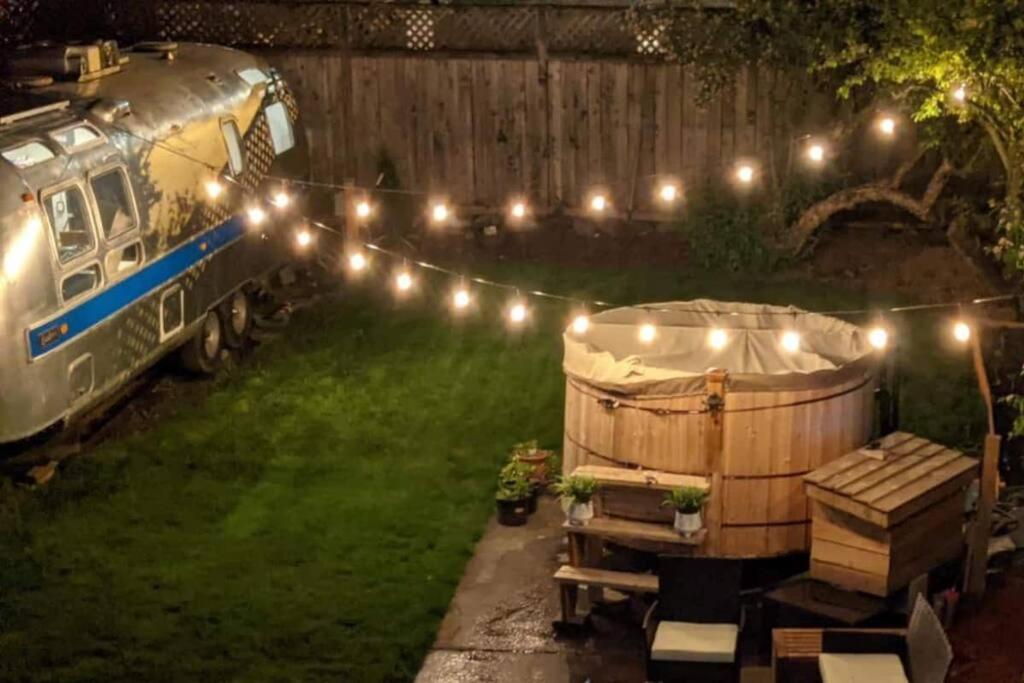 a yard with a fence with lights and a barrel at Northwest Retreat with Cedar Hot Tub in Seattle