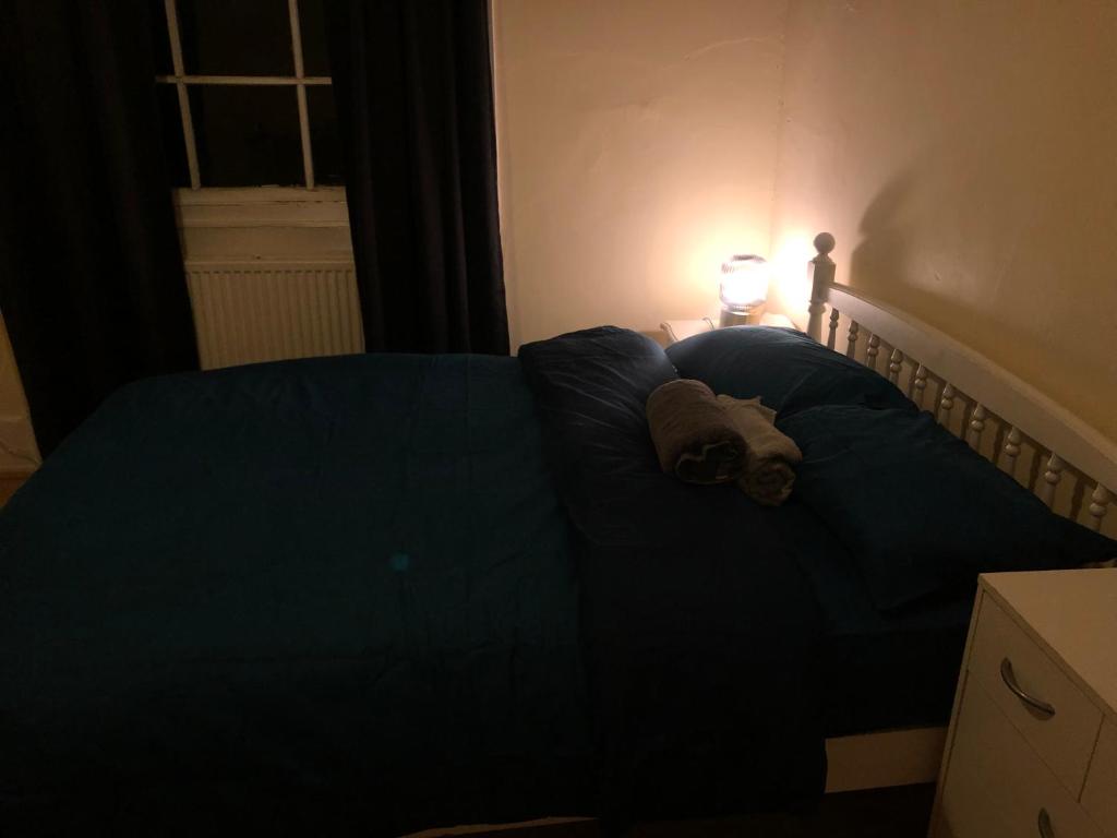 Łóżko w ciemnym pokoju z misiem. w obiekcie Private room in Highgate London w Londynie