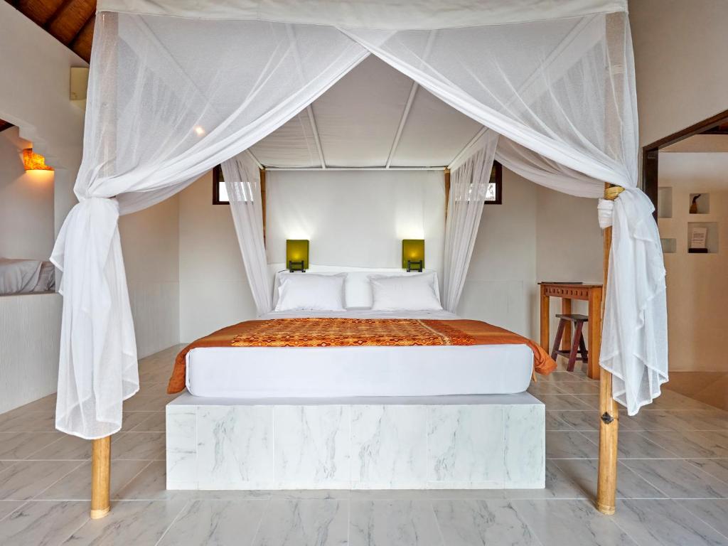 a bedroom with a bed with a canopy at Anda Amed Villas & Spa in Amed