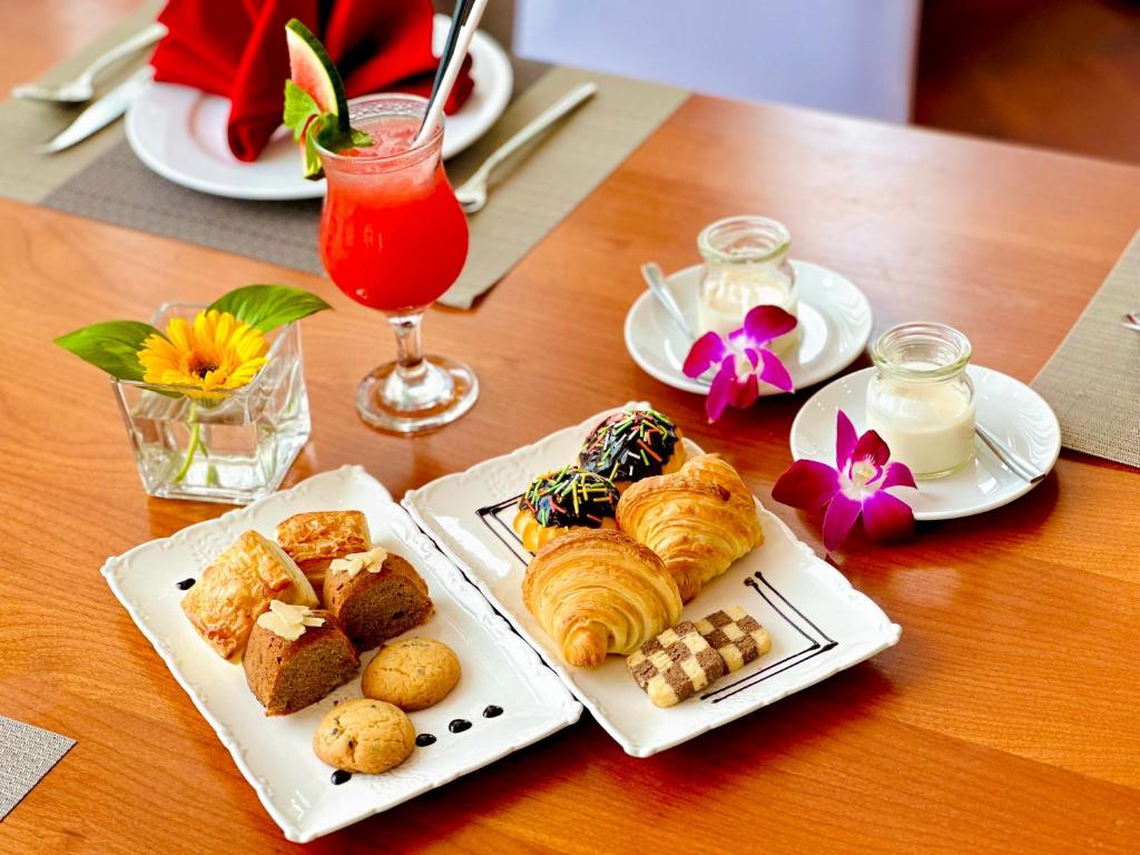 A styled table of pastries, yogurt and a red fruit drink.