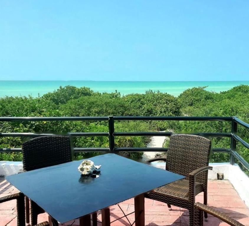 a blue table and chairs on a balcony with the ocean at Casa Nora in Sisal