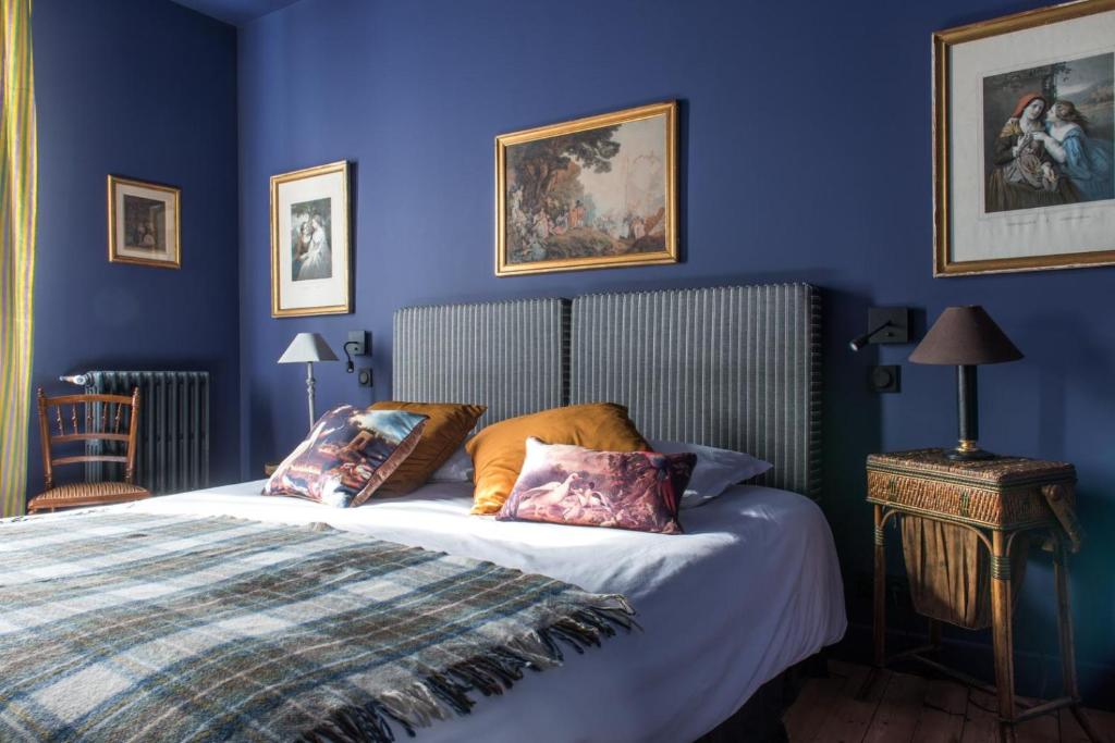 a bedroom with blue walls and a bed with pillows at La Villa Augustine in Dieppe