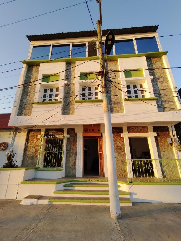 a building with a pole in front of it at Natz Hotel in Flores