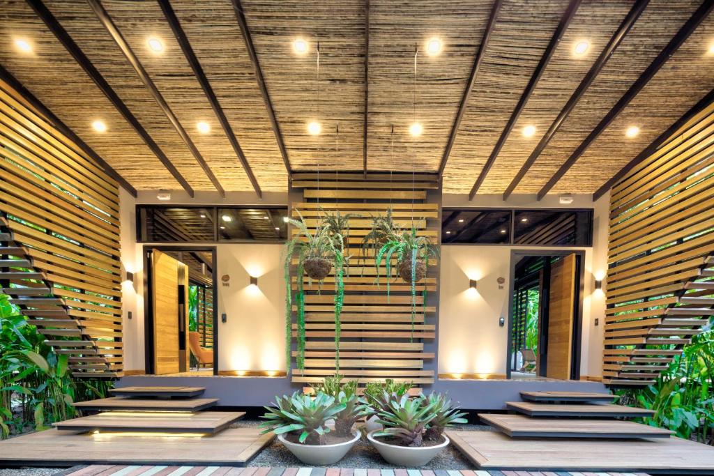 a lobby with stairs and potted plants at aWà Beach Hotel in Puerto Viejo