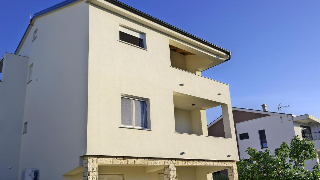 a tall white building with windows on the side of it at Apartment Karmen in Šilo