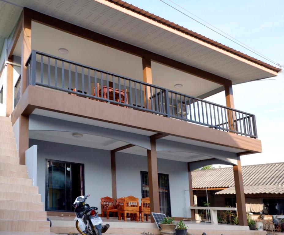 una casa con balcón con una moto aparcada en la parte delantera en WS HOUSE KRABI, en Ban Ko Kwang