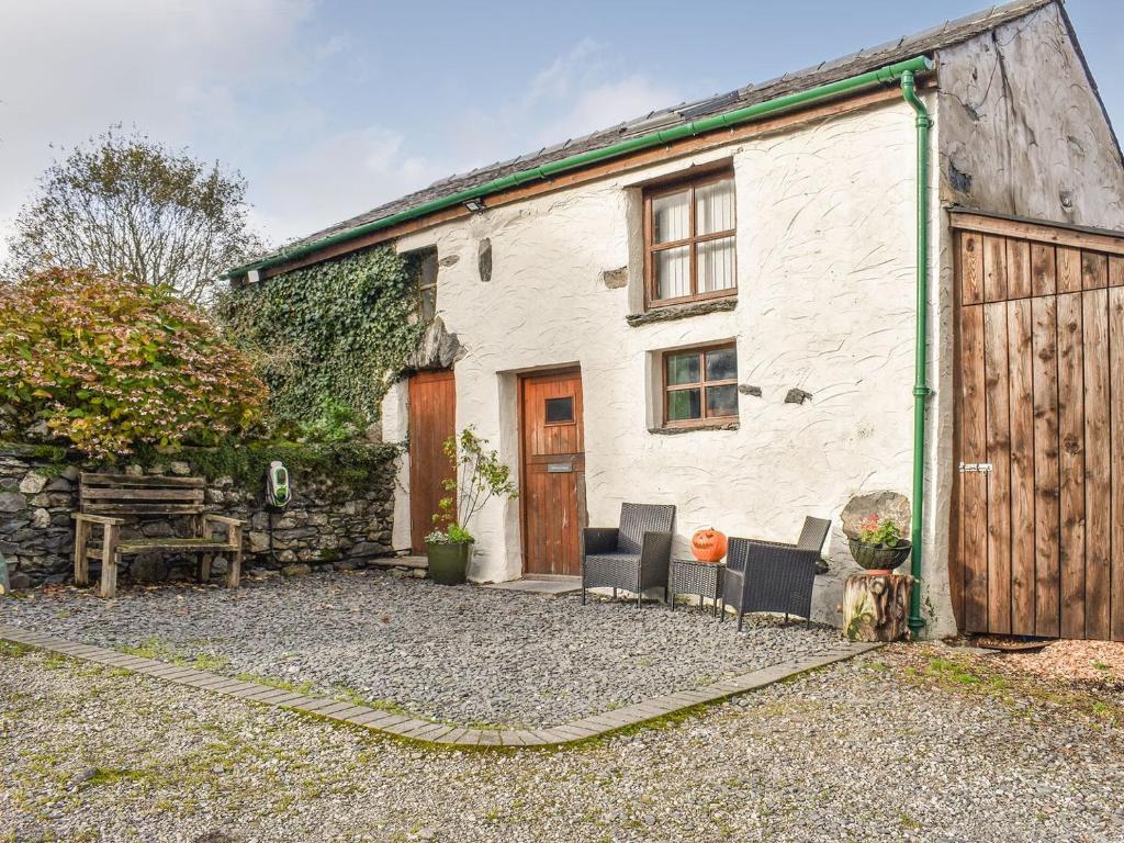 a cottage with a wooden door and chairs in front of it at The Cottage - Ukc6140 in Cartmel