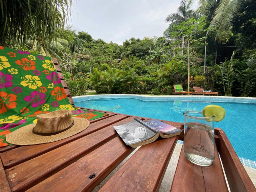 un sombrero sentado en una mesa de madera junto a una piscina en Hotel Entre Dos Aguas en Sámara