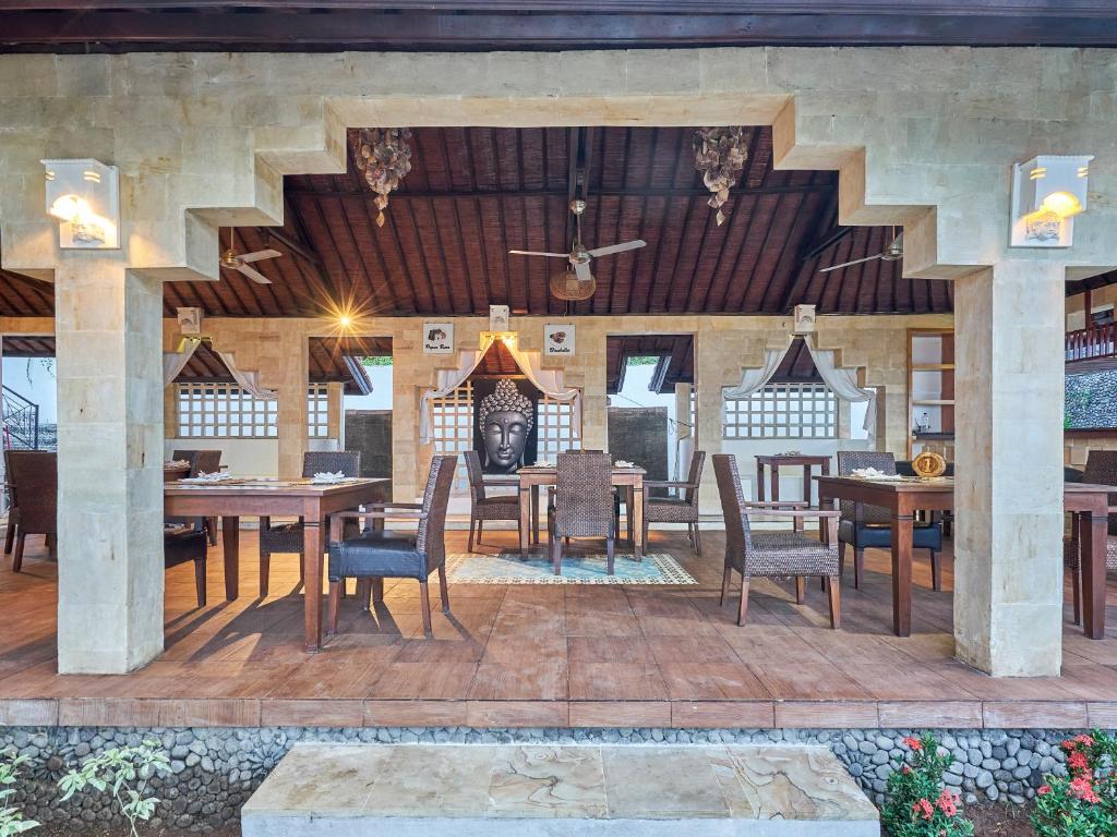 a dining room with tables and chairs and a ceiling at Anda Amed Villas & Spa in Amed