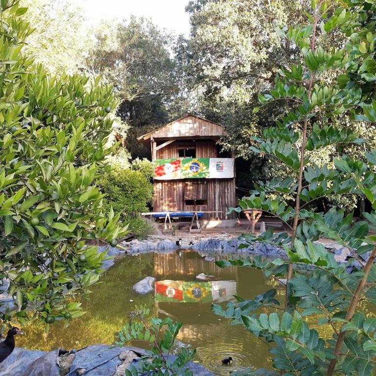 a garden with a house in the middle of a pond at Instituto Bugio Ruivo in Eldorado do Sul 