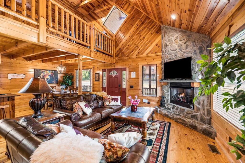 a living room with leather furniture and a fireplace at Bear Tracks in Gatlinburg