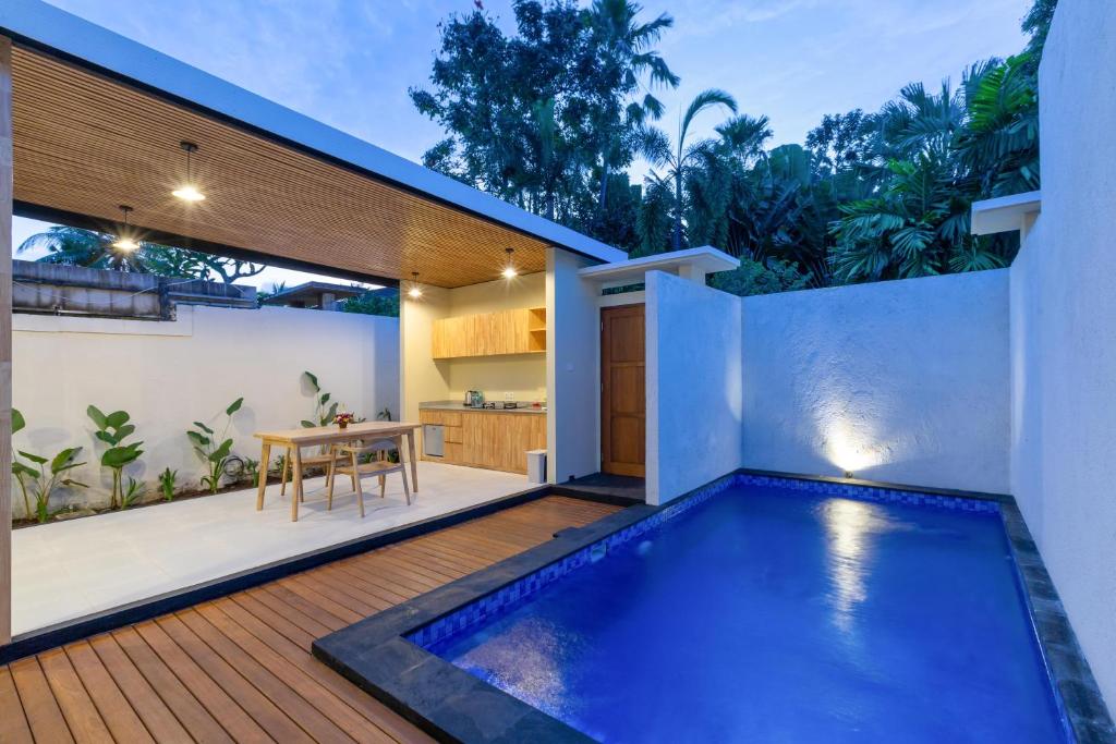 a backyard with a swimming pool and a house at Paisa Villa Seminyak in Seminyak