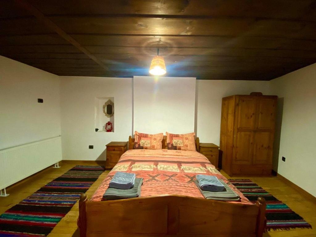 Un dormitorio con una cama grande con una alfombra grande en Къща за гости Близнаците en Leshten