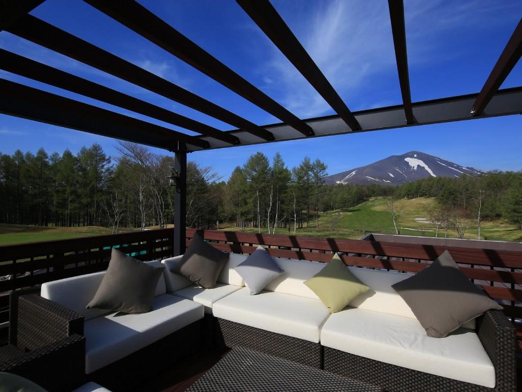 - un canapé sur une terrasse avec vue sur la montagne dans l'établissement Villa the Club Karuizawa, à Naganohara