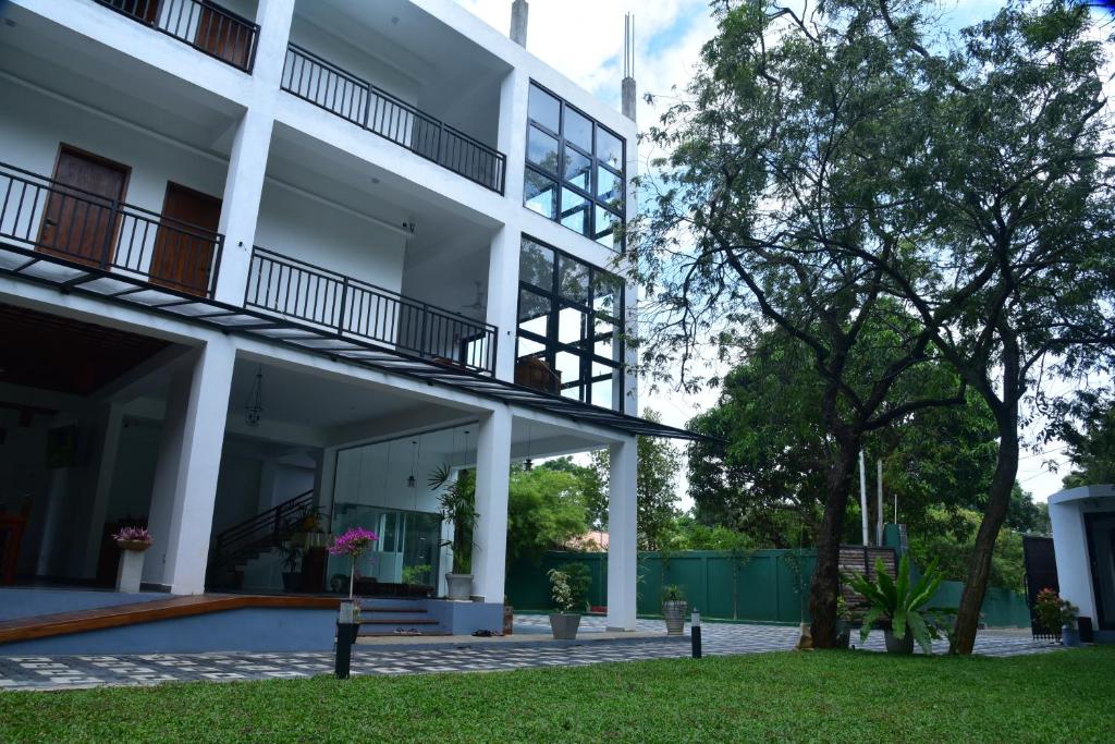 an external view of a white building with a courtyard at Eden Grand in Dambulla
